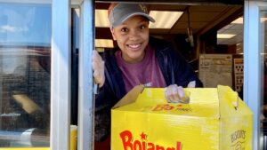 Bojangles staff member smiling while handing an order out of the drive thru window